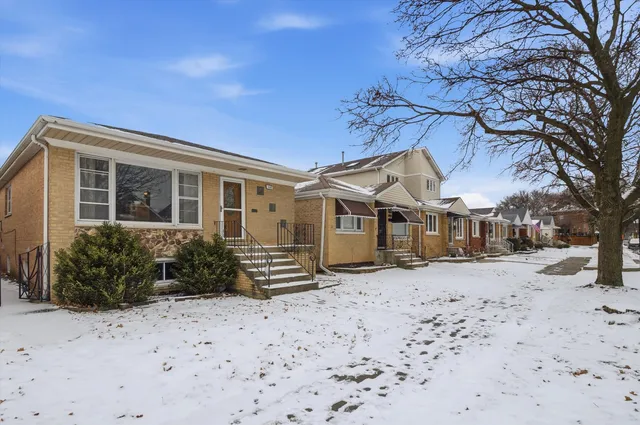 a front view of a house with a yard covered in snow