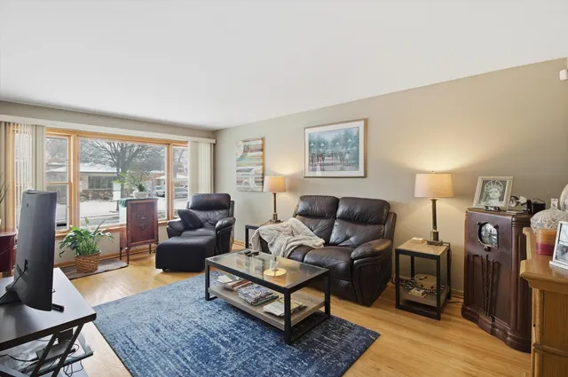 a living room with furniture a rug a lamp and a large window
