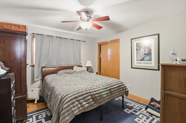 a bedroom with a bed and a refrigerator