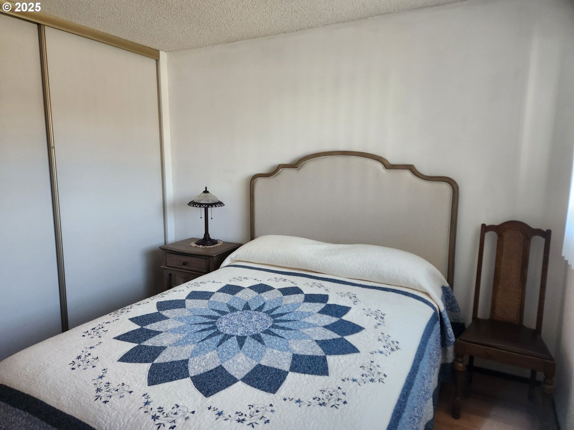 950 Evergreen Road, Unit 229 Woodburn, OR 97071 - Photo 14 of 33 a bedroom with a bed and wooden floor