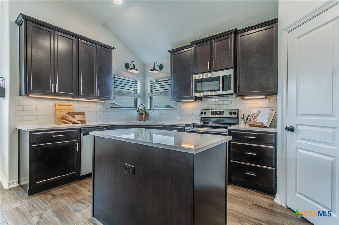8304 Split Trl Cove Temple, TX 76502 - Photo 5 of 28 a kitchen with stainless steel appliances granite countertop a stove microwave and sink
