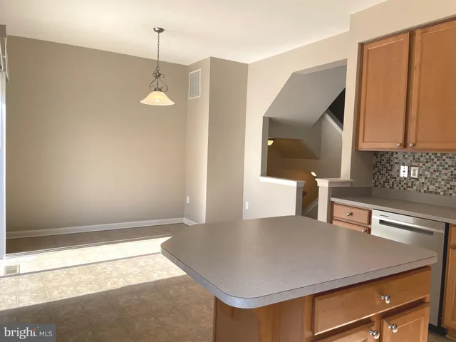 a kitchen with a table chairs and a refrigerator