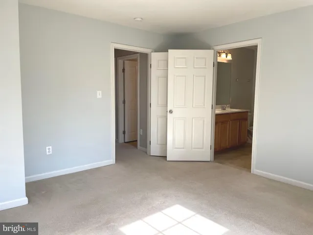 an empty room with closet and windows
