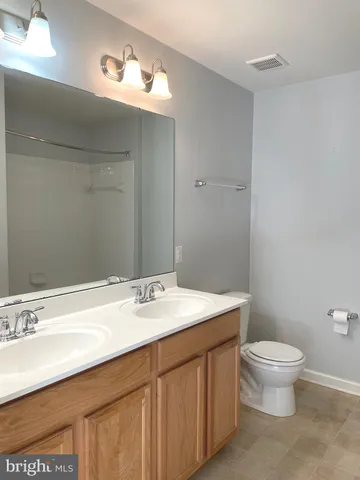 a bathroom with a sink a toilet and mirror
