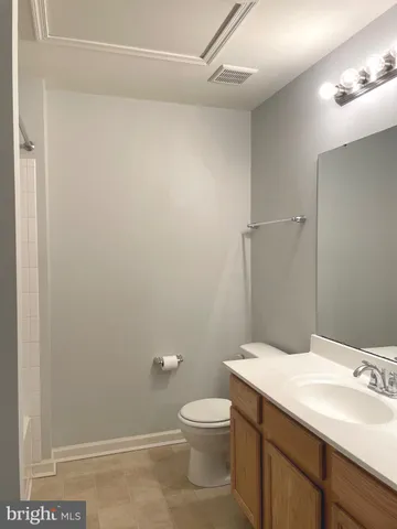 a bathroom with a granite countertop toilet and a sink