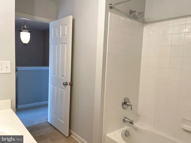 a bathroom with a tub shower and sink