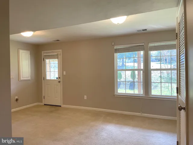 an empty room with windows and closet