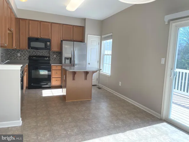 a kitchen with stainless steel appliances granite countertop a refrigerator a stove top oven a sink and dishwasher