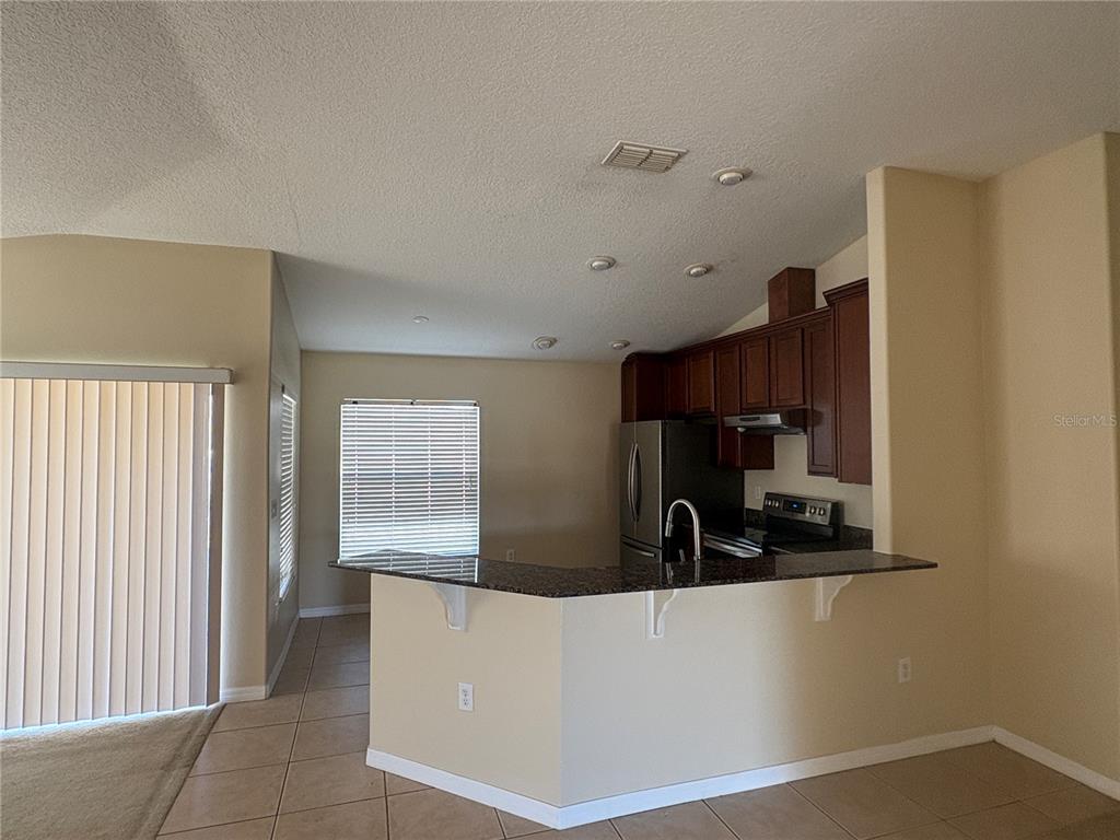 3878 Prescott Loop Lakeland, FL 33810 - Photo 3 of 12 a kitchen with cabinets and a refrigerator