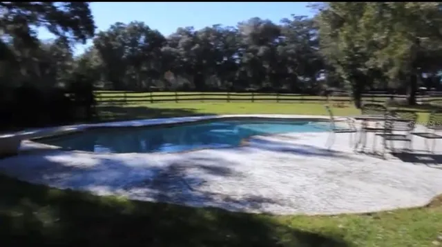 a view of a swimming pool and a yard