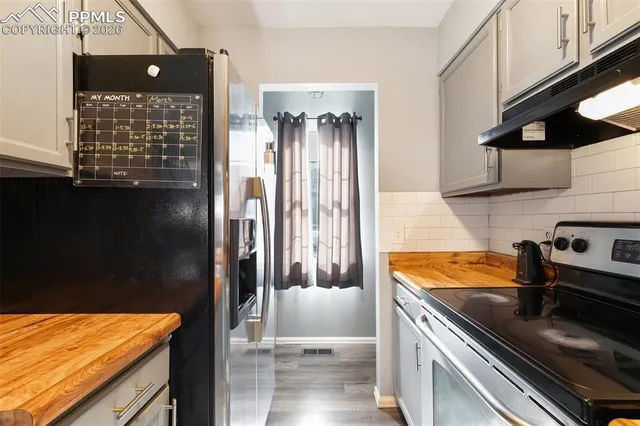 a kitchen with stainless steel appliances granite countertop a refrigerator and a stove