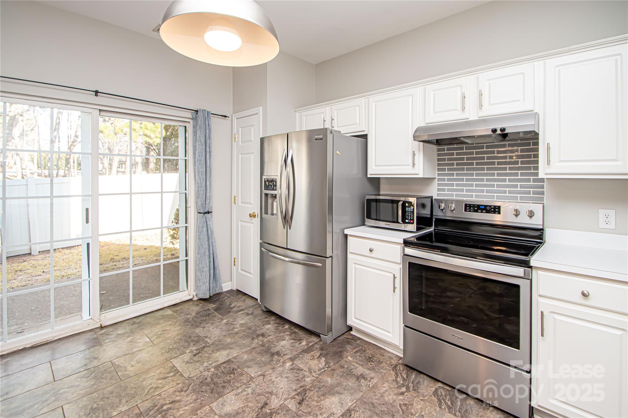 2121 Kaybird Lane Charlotte, NC 28270 - Photo 12 of 39 a kitchen with a stove a refrigerator and a cabinets