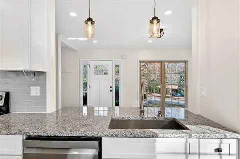 a view of living room with granite countertop a couch and chandelier