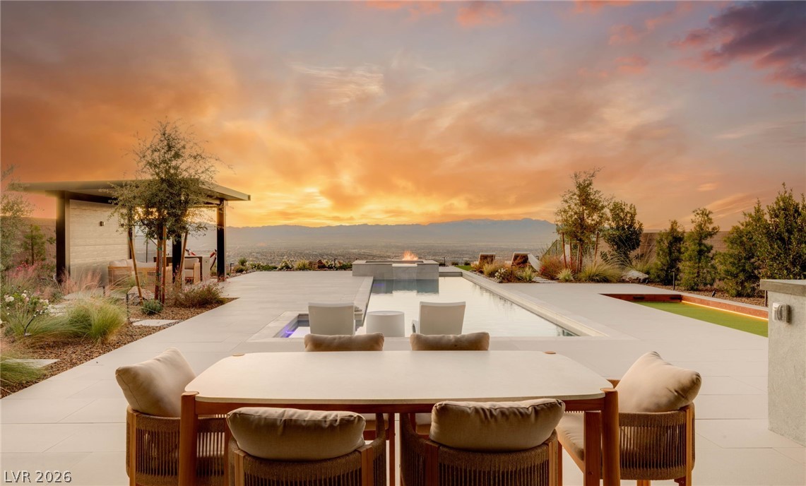 571 Overlook Rim Drive Henderson, NV 89012 - Photo 43 of 85 Patio terrace at dusk with a patio, outdoor dining area, and a fire pit