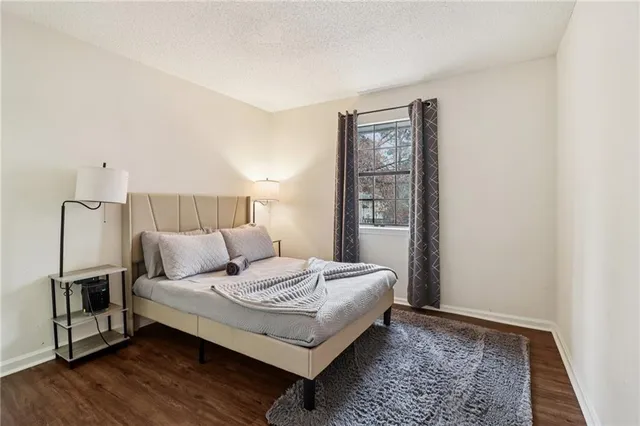 a bedroom with a bed rug and wooden floor