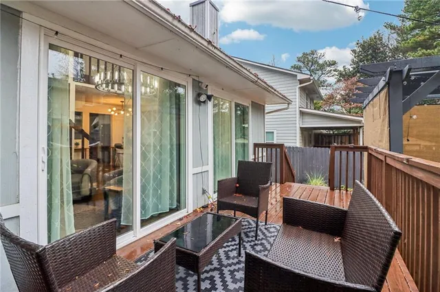 a balcony with wooden floor and outdoor seating