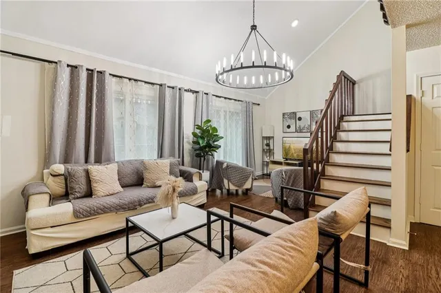 a living room with furniture a dining table and a chandelier