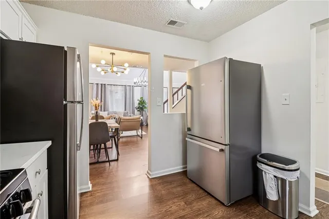 a kitchen with a refrigerator a stove and a dining table