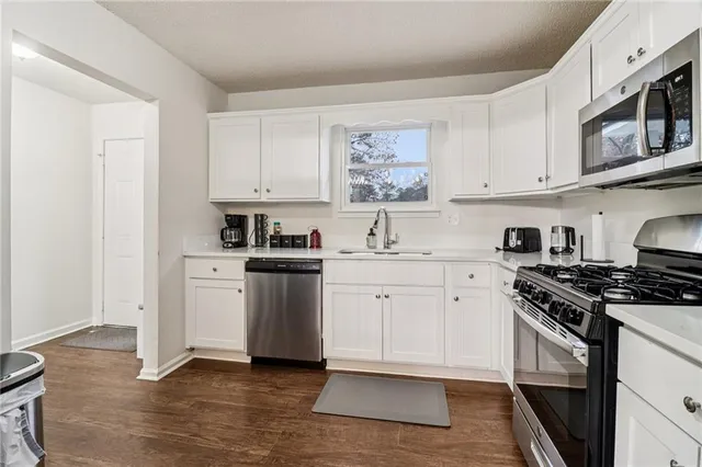 a kitchen with stainless steel appliances granite countertop a stove a sink and a refrigerator