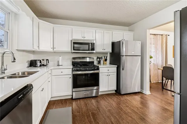 a kitchen with stainless steel appliances a refrigerator sink and cabinets