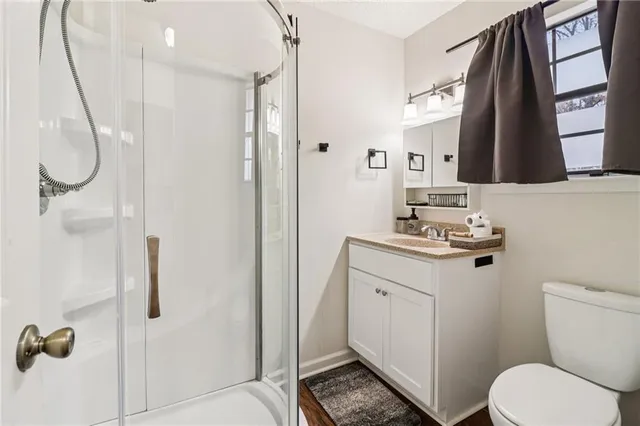 a bathroom with a granite countertop sink toilet and shower