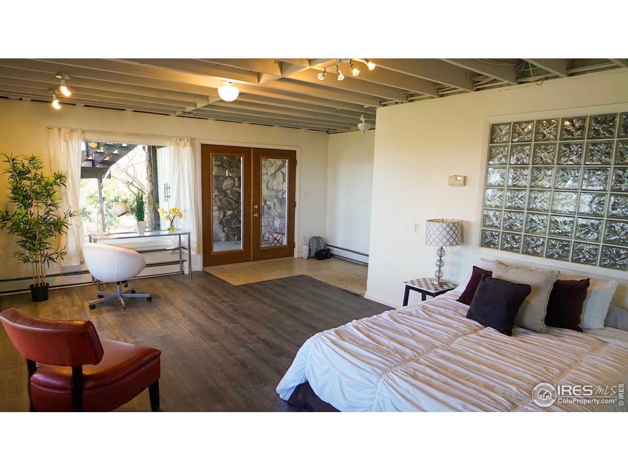 57 Acorn Lane Boulder, CO 80304 - Photo 17 of 40 a bedroom with a bed and wooden floor