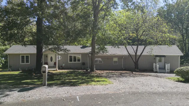 a living room with furniture a flat screen tv and a large window