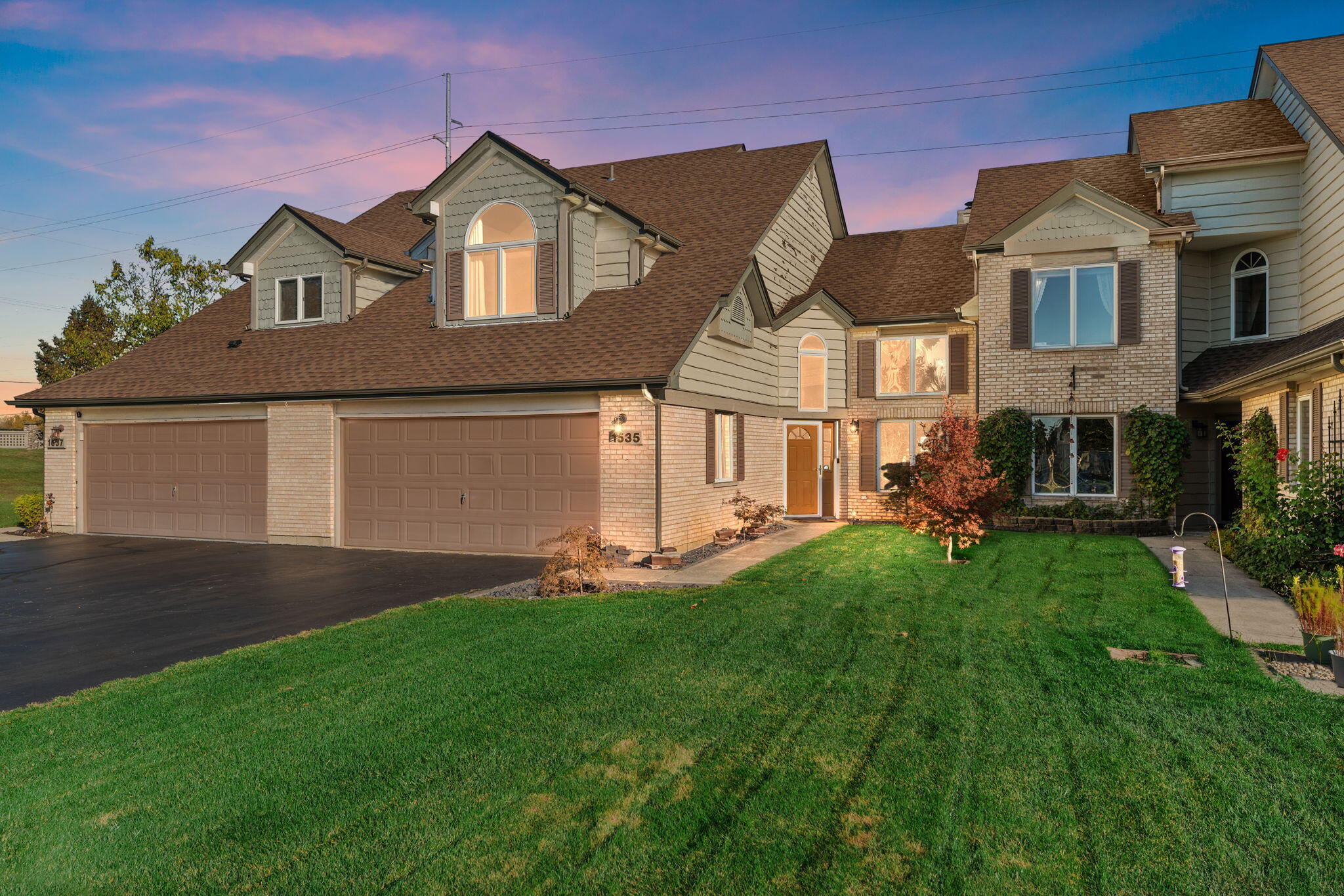 a front view of a house with a yard and garage