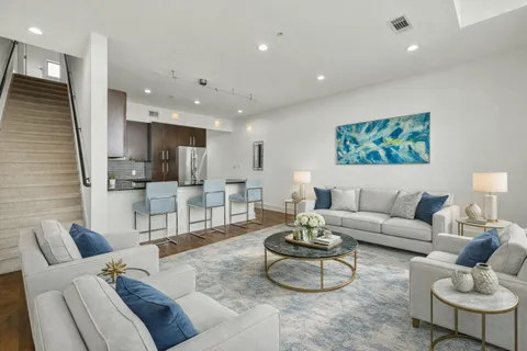 a living room with furniture and kitchen view