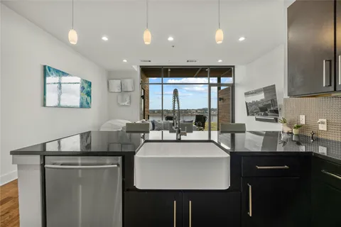 a kitchen with counter top space a sink appliances and cabinets