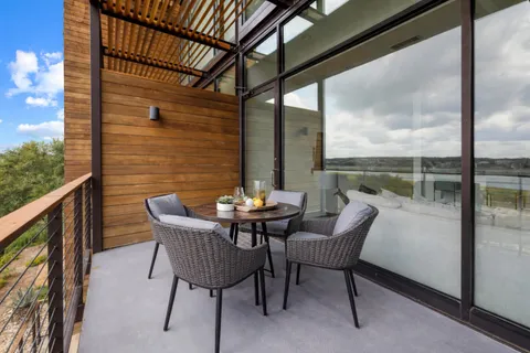 a view of a chair and tables in the balcony