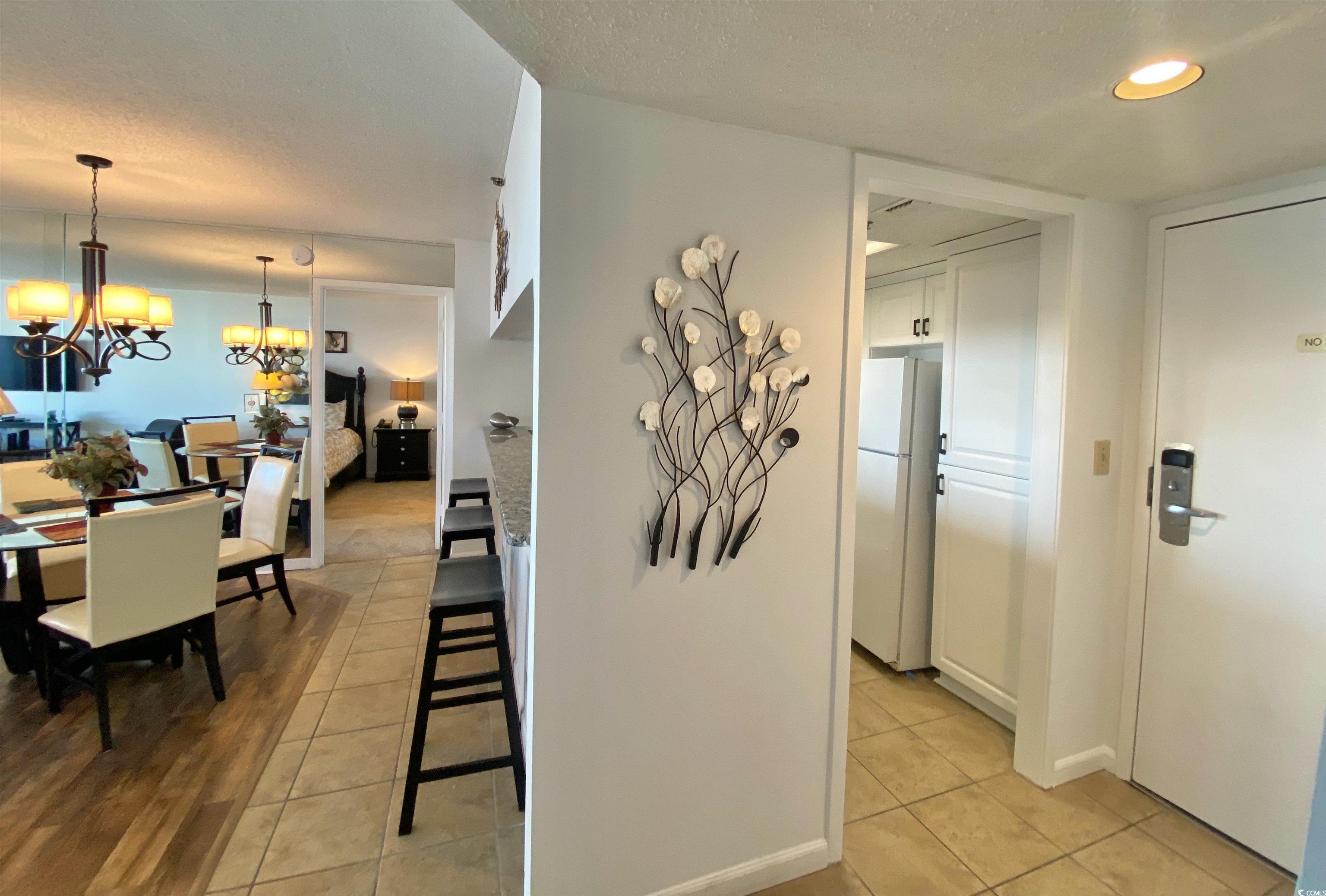 9820 Queensway Boulevard, Unit 206 Myrtle Beach, SC 29572 - Photo 14 of 40 Dining area with a textured ceiling, a notable chandelier, and light tile patterned flooring