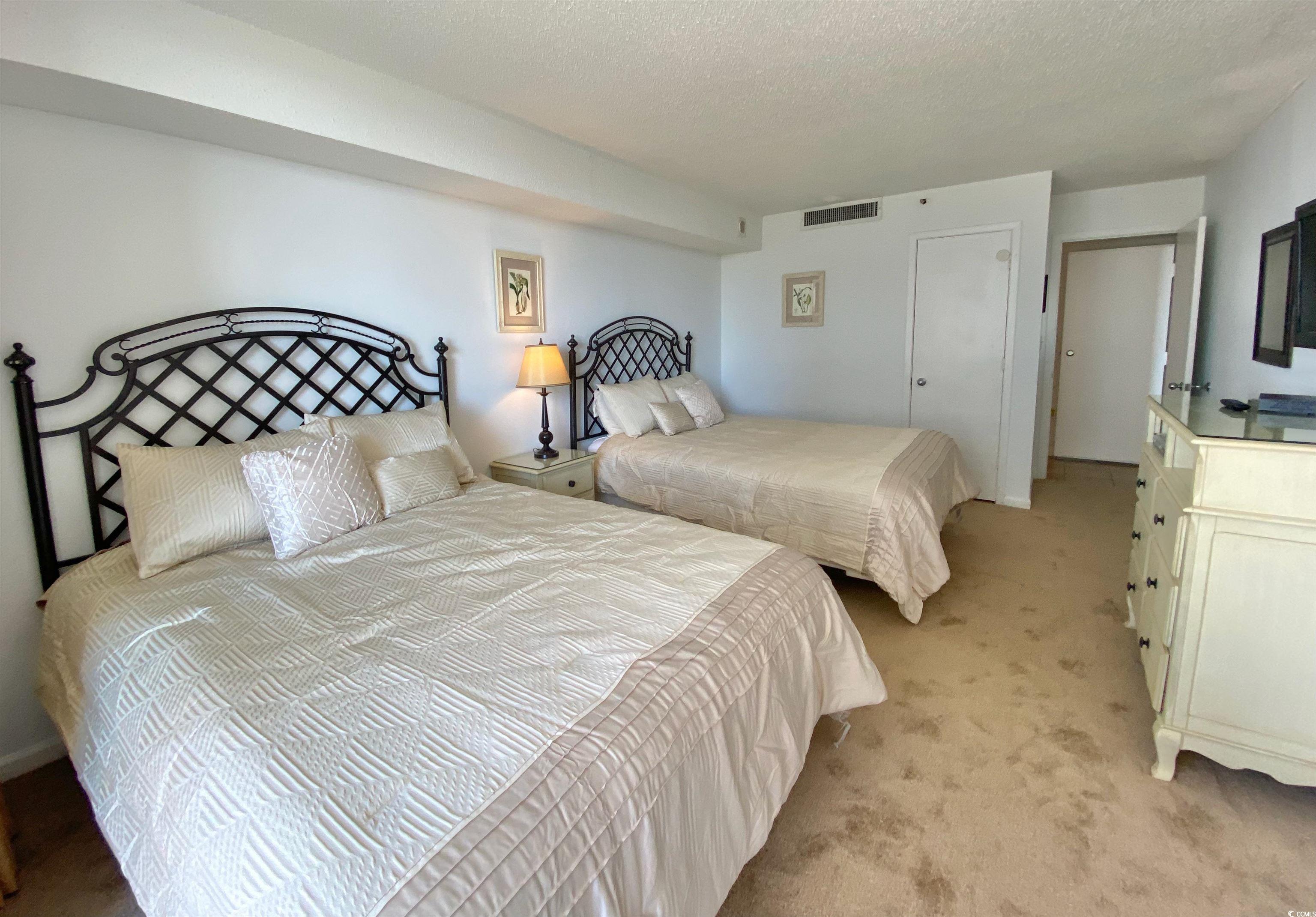 9820 Queensway Boulevard, Unit 206 Myrtle Beach, SC 29572 - Photo 23 of 40 Bedroom with a textured ceiling and light colored carpet