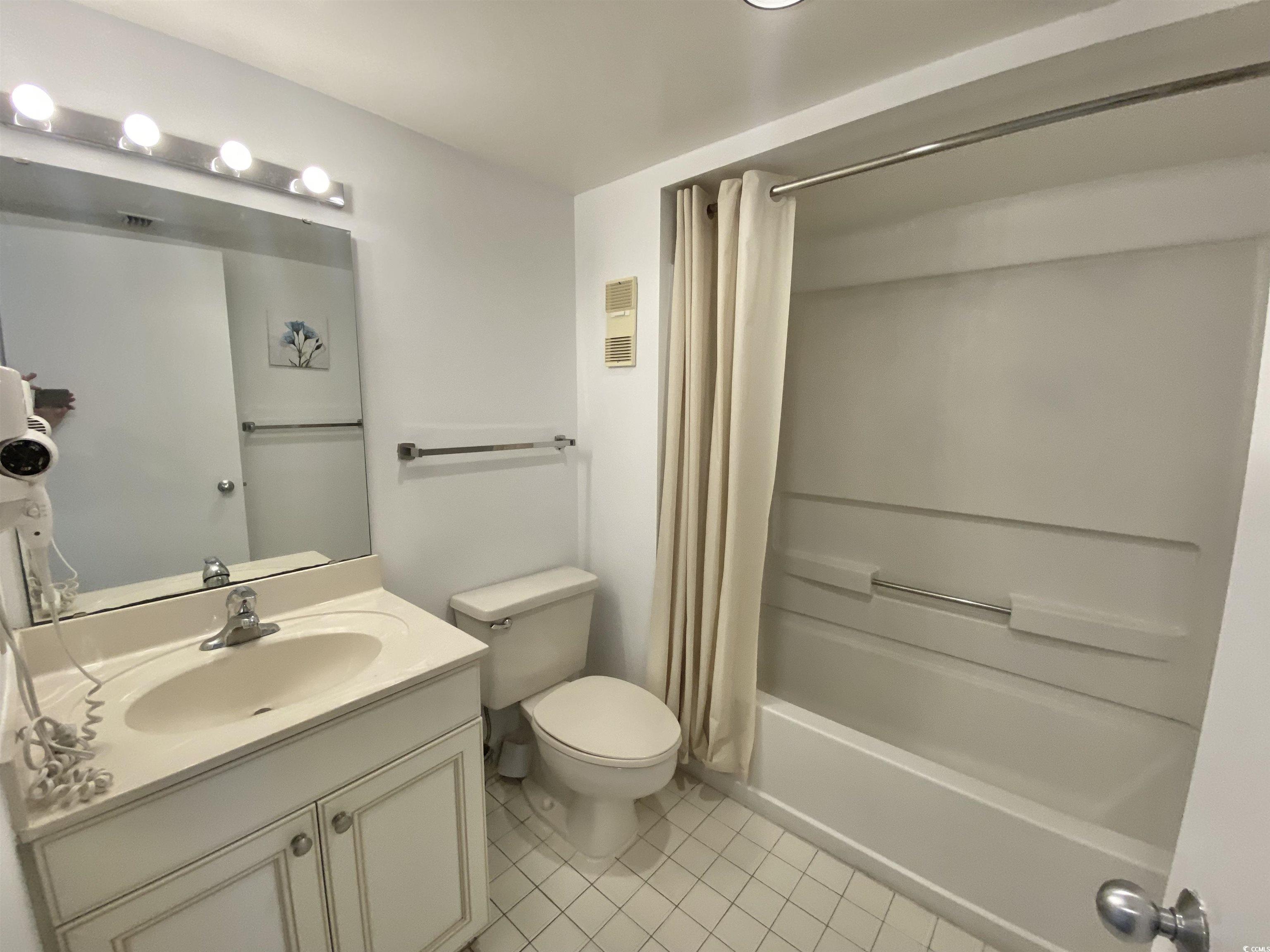 9820 Queensway Boulevard, Unit 206 Myrtle Beach, SC 29572 - Photo 29 of 40 Full bathroom featuring toilet, shower / tub combo, tile patterned floors, and vanity
