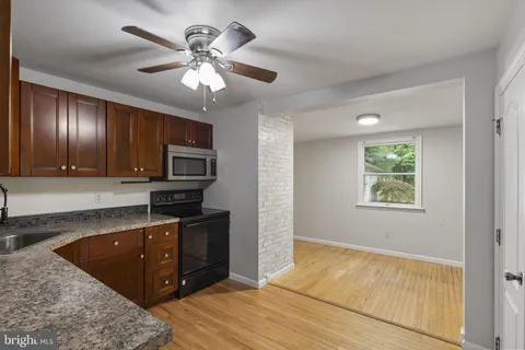 a kitchen with granite countertop a refrigerator and a stove top oven