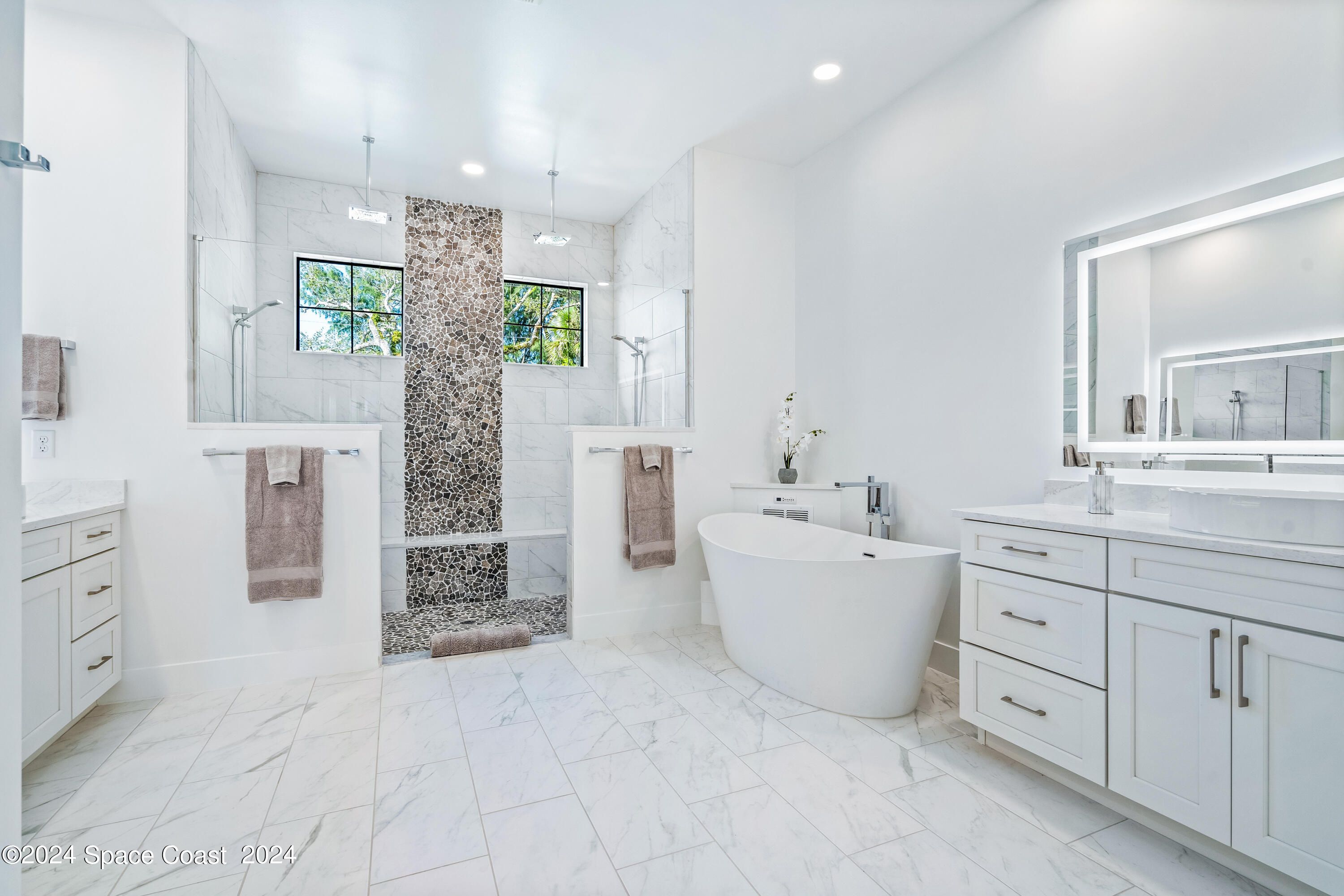 Undisclosed Address Vero Beach, FL 32963 - Photo 26 of 36 a bathroom with a granite countertop sink a bathtub a mirror a vanity and shower