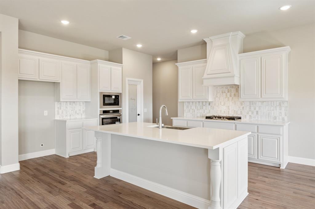 200 Eagle Vw Lane Commerce, TX 75428 - Photo 11 of 34 a kitchen with a sink a stove a refrigerator and white cabinets