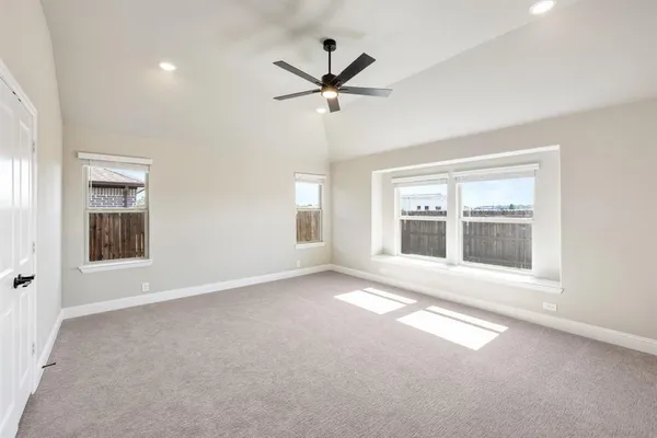 an empty room with windows and ceiling fan