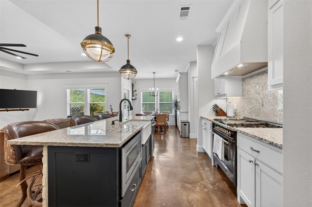 6371 Mill Run Road Athens, TX 75751 - Photo 6 of 40 The kitchen features white cabinetry, a large kitchen island with a farmhouse sink, granite countertops, and an ILVE custom commercial range with a matching hood
