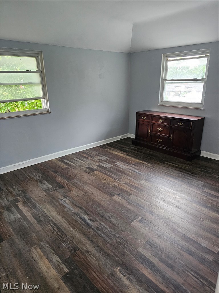 3855 Strandhill Road Cleveland, OH 44128 - Photo 4 of 7 Unfurnished room featuring a wealth of natural light, dark wood-type flooring, and vaulted ceiling