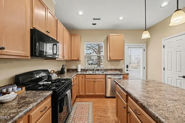 a kitchen with stainless steel appliances granite countertop a stove sink and cabinets