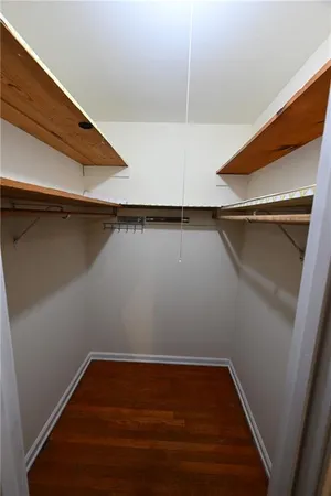 a view of walk in closet with wooden floor
