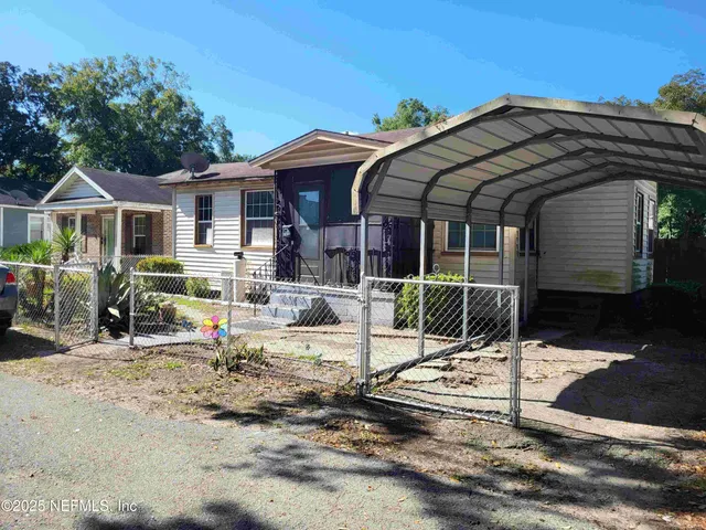 a view of a house with backyard and sitting area