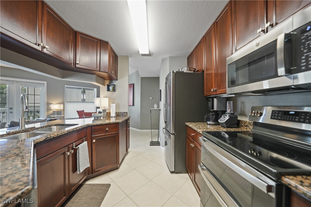 950 Moody Road, Unit 140 North Fort Myers, FL 33903 - Photo 4 of 46 a kitchen with stainless steel appliances granite countertop a stove refrigerator and cabinets
