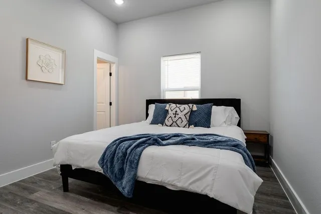 a bedroom with a bed and a painting on the wall