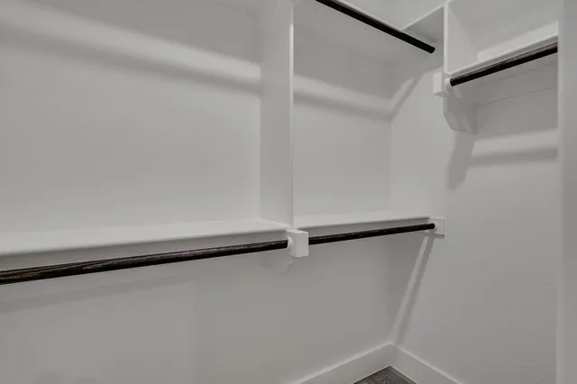 a large bed sitting in a bedroom next to a window