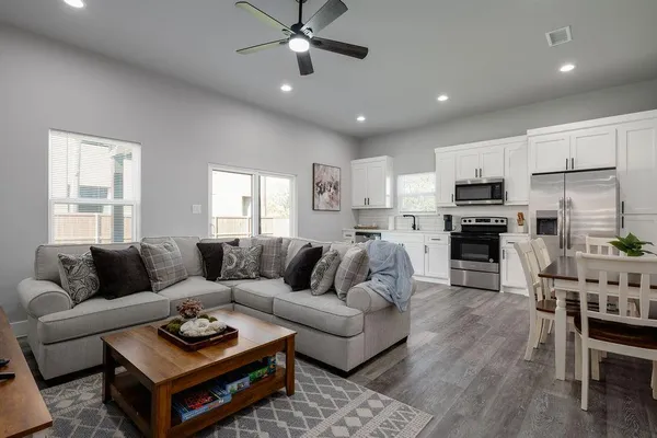 a living room with furniture kitchen and a table