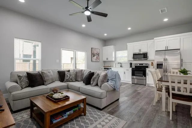 a living room with furniture kitchen and a table