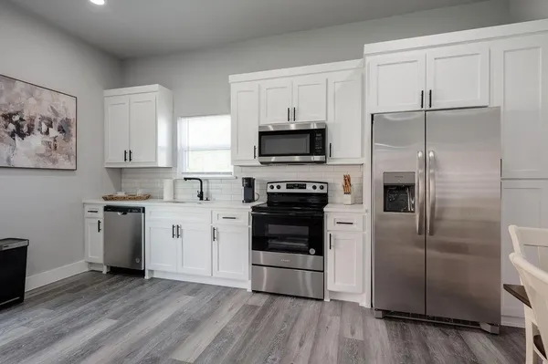 a kitchen with a refrigerator stove and wooden cabinets