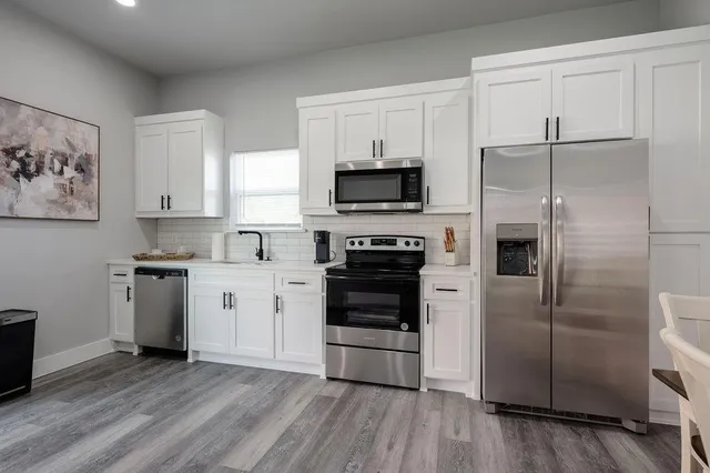 a kitchen with a refrigerator stove and wooden cabinets